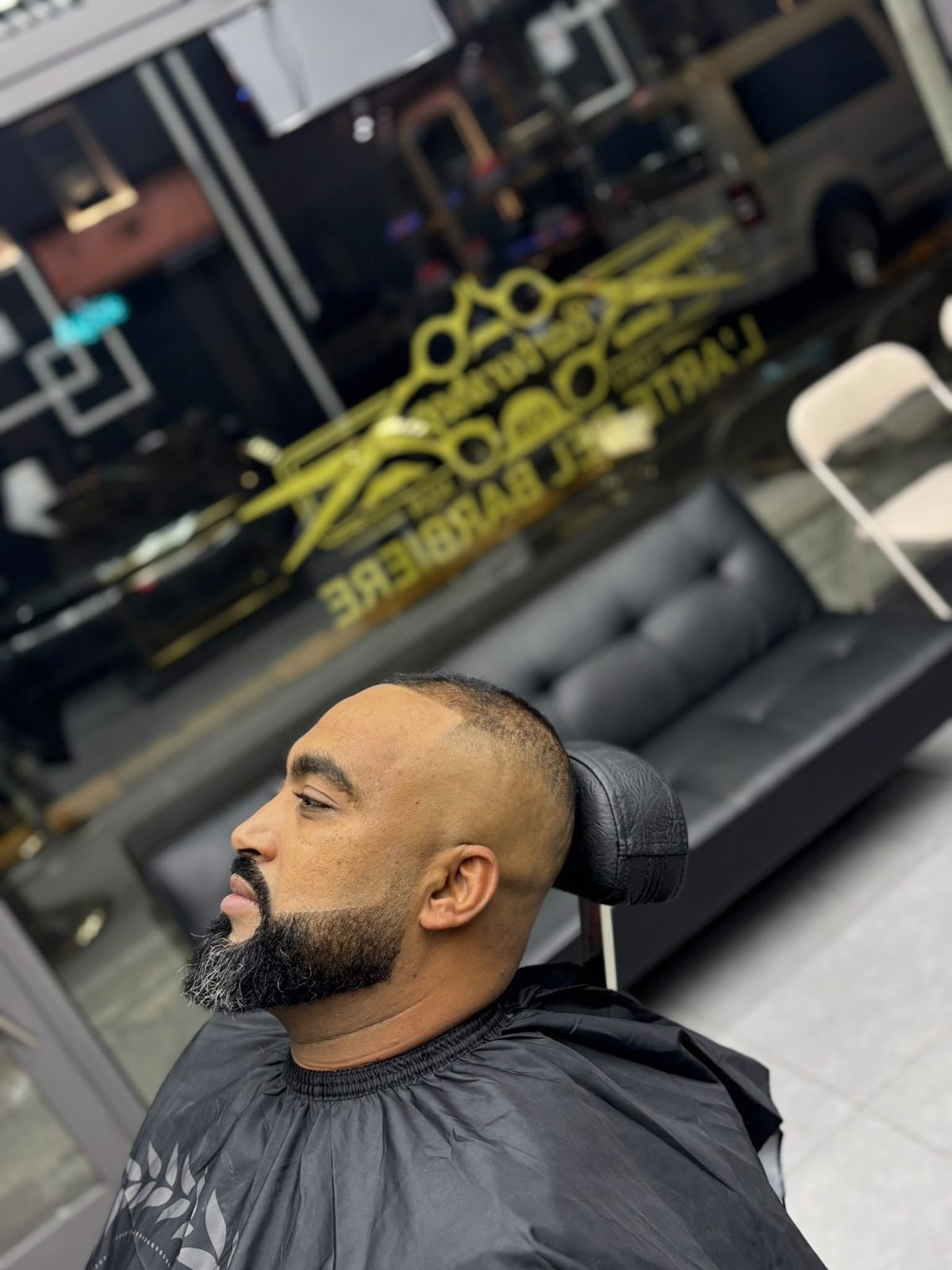 Capelli rasati corti con high fade e barba piena rifinita