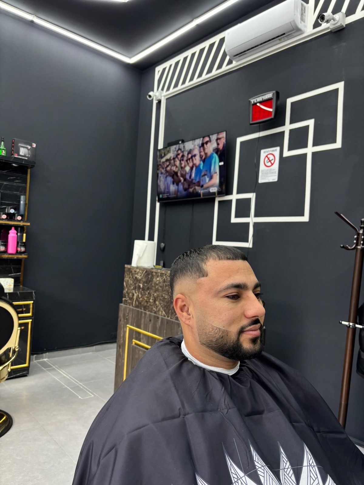 Taglio corto con frangia dritta, skin fade e barba definita